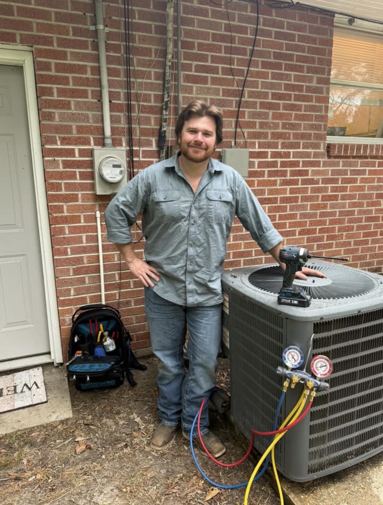H & H technician servicing an outdoor air conditioning unit